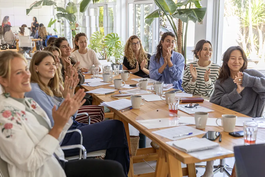 A daytime workshop around a long table in a bright room