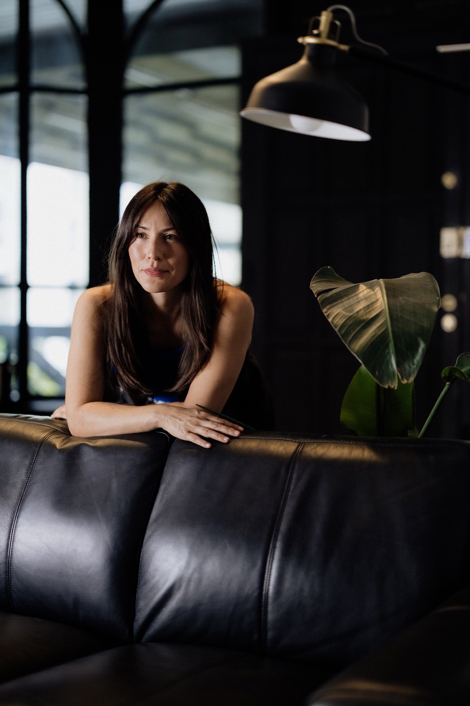 Jennifer Nunez leaning on the back of a leather sofa
